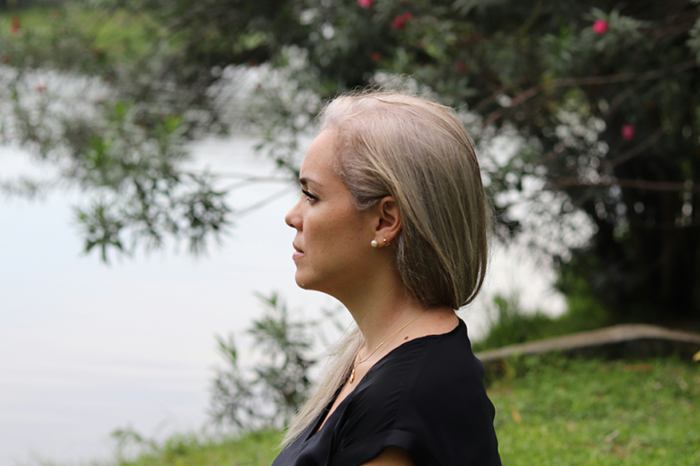 Woman outdoors looking calm and reflective, representing stress and emotional wellness