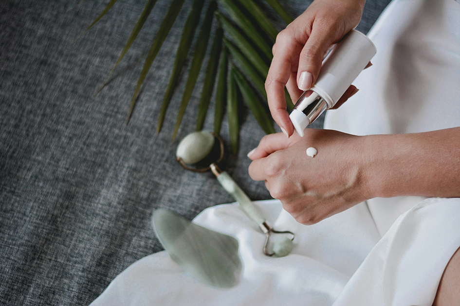 Woman applying moisturizer to support healthy glowing skin