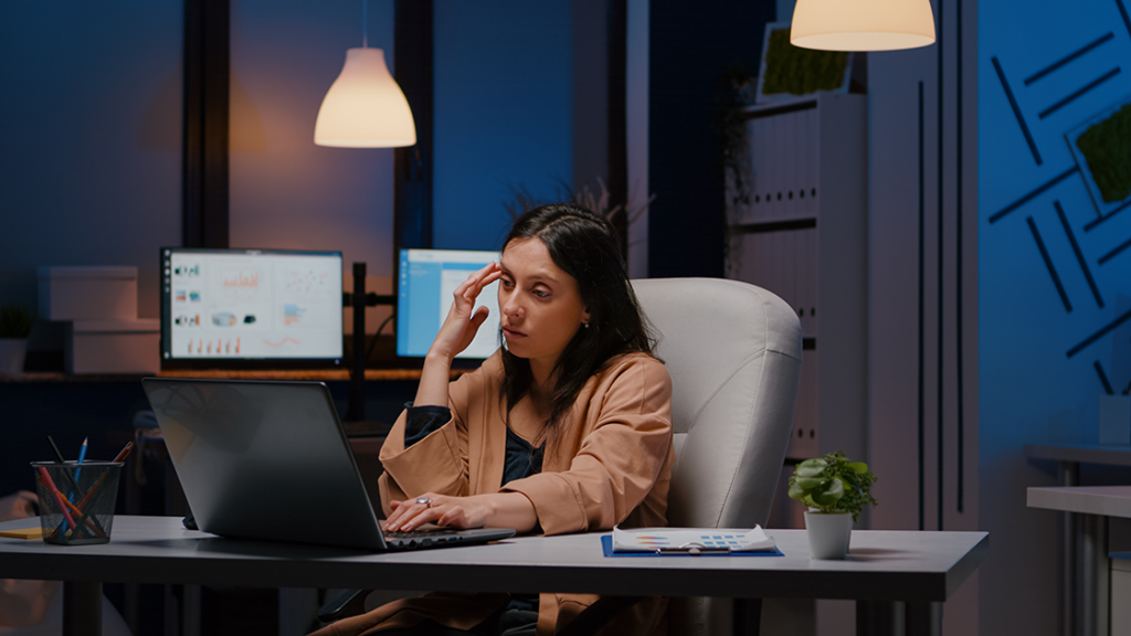 Woman feeling stressed and overwhelmed in a workplace environment