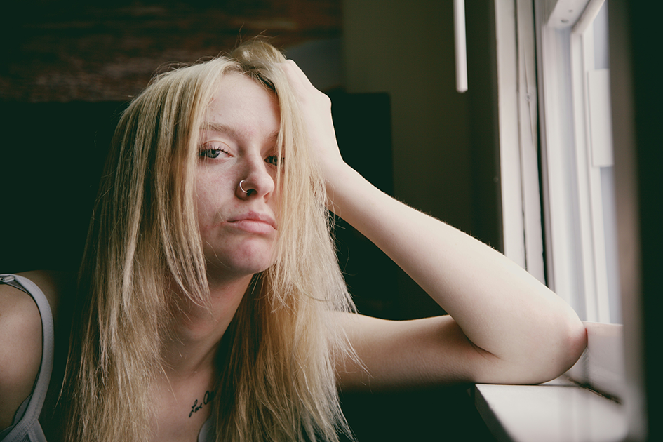 Woman sitting quietly at home feeling mentally exhausted and emotionally drained