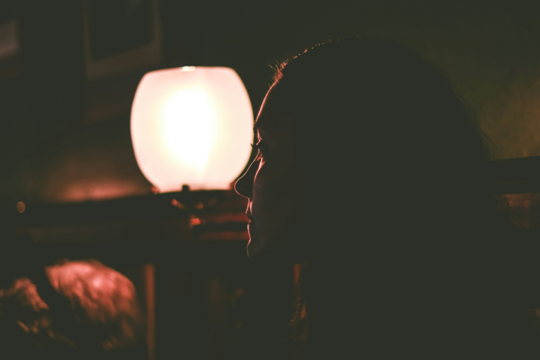 Woman relaxing at night while calming racing thoughts before sleep