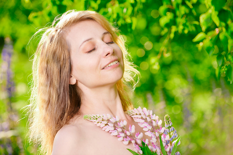 Woman with healthy skin enjoying fresh air and sunshine in a natural outdoor setting