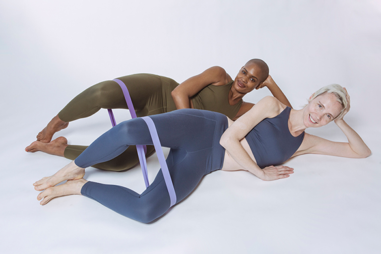 Two women exercising with resistance bands to strengthen their glutes and legs