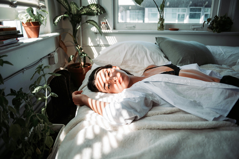 Woman lying awake in bed, illustrating how hormone imbalances may affect sleep quality and energy levels