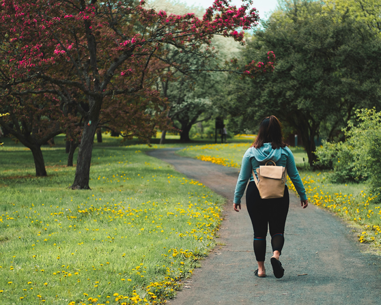 Woman walking outdoors on a sunny day as part of a healthy weight loss and fitness routine