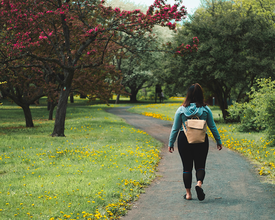 Woman walking outdoors on a sunny day as part of a healthy weight loss and fitness routine