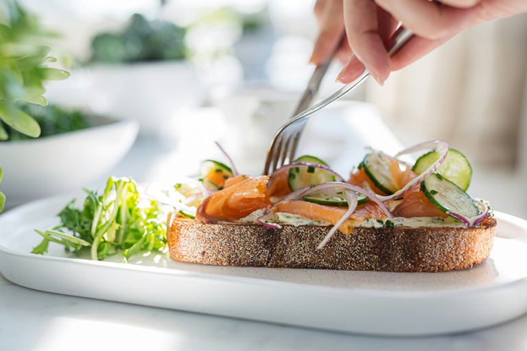 Balanced meal with whole-grain toast, smoked salmon, cucumber, red onion, and fresh greens