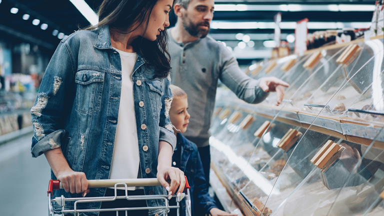 Pregnant woman grocery shopping and choosing safe foods during pregnancy