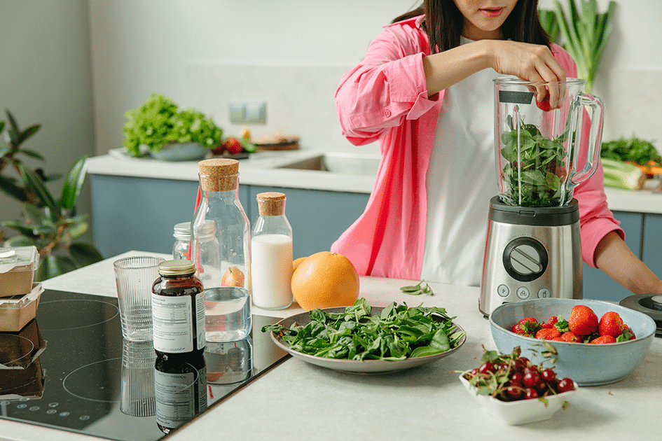Blender on a bright kitchen counter with smoothie ingredients