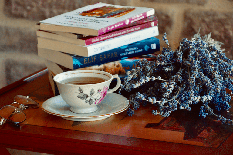 Stack of popular anxiety workbooks on a wooden table with a cup of herbal tea