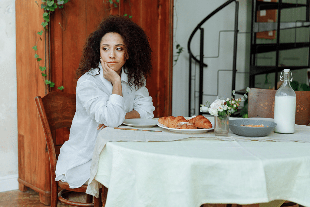 Woman experiencing bloating and digestive discomfort at table