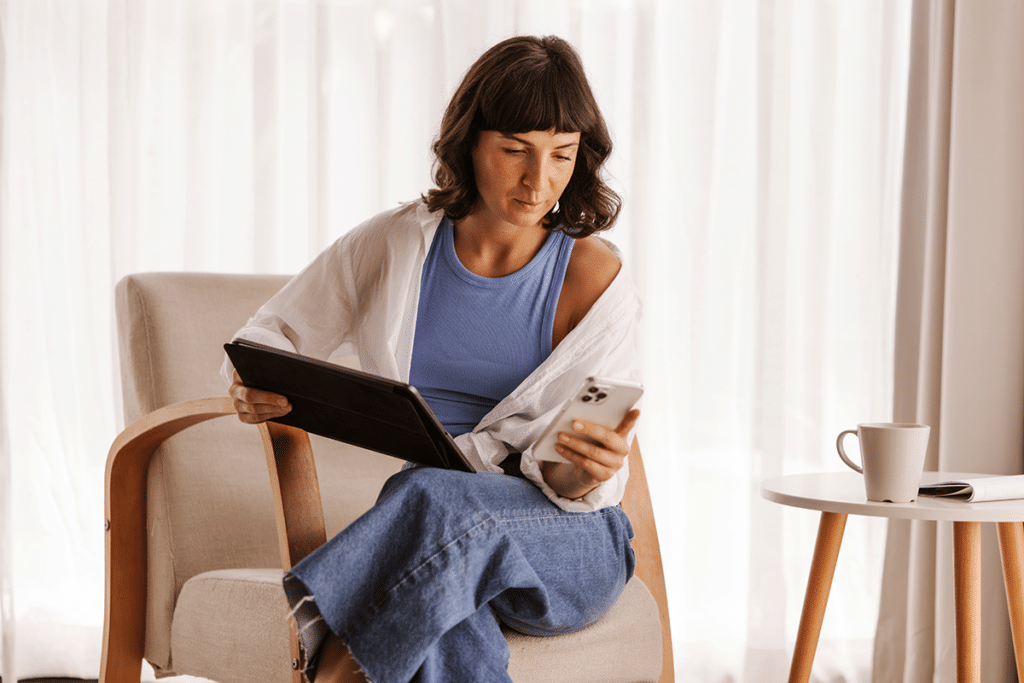 Woman using a tablet and phone to track menstrual cycle changes