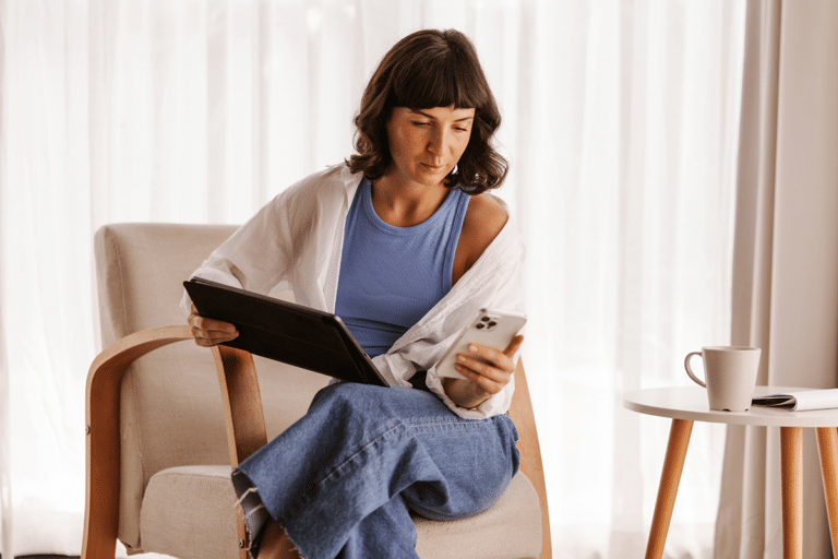Woman using a tablet and phone to track menstrual cycle changes
