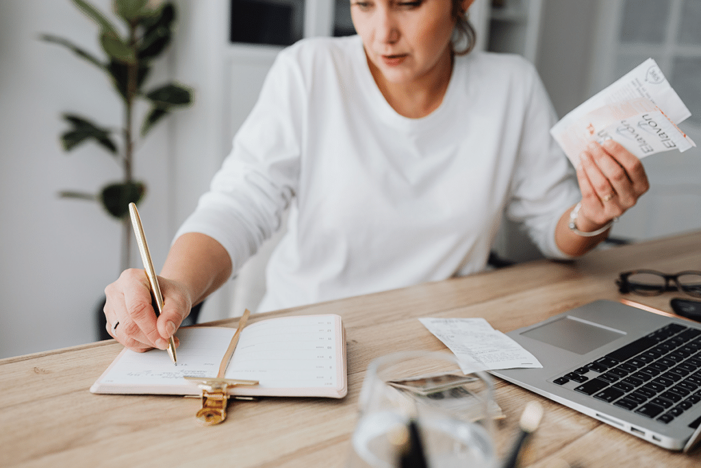 Woman planning daily tasks, reviewing bills, and organizing her schedule while managing the mental load of everyday responsibilities