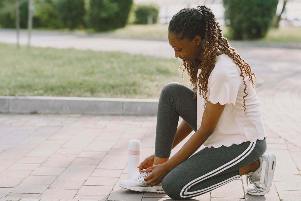 Woman tying comfortable walking shoes before a morning walk