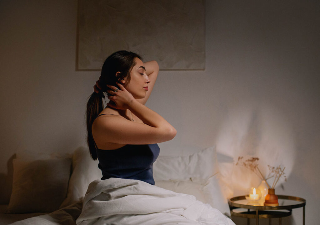 Woman preparing for sleep in a calm, softly lit bedroom