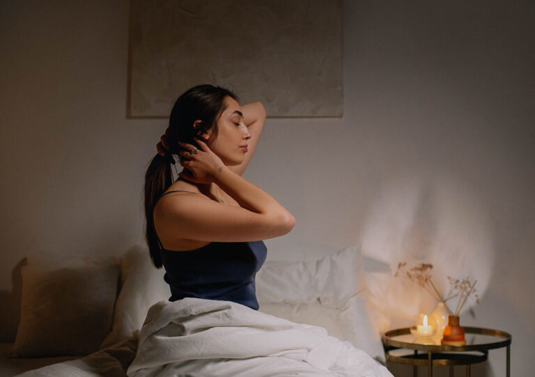 Woman preparing for sleep in a calm, softly lit bedroom