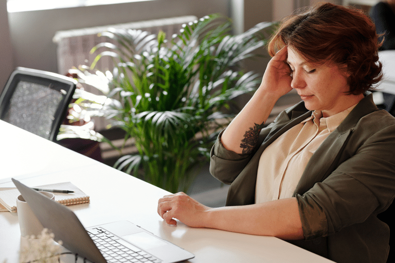 Woman in her 40s struggling to focus while working, illustrating forgetfulness and brain fog during perimenopause