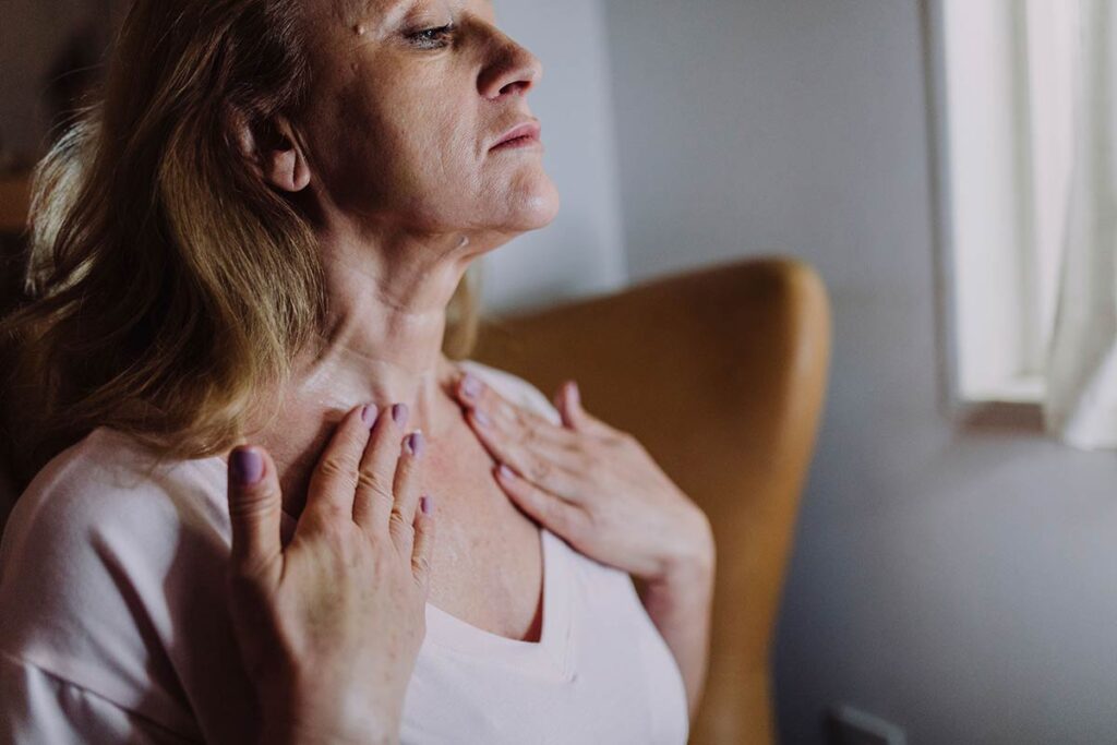 Woman in her 50s experiencing dry skin on her neck during menopause
