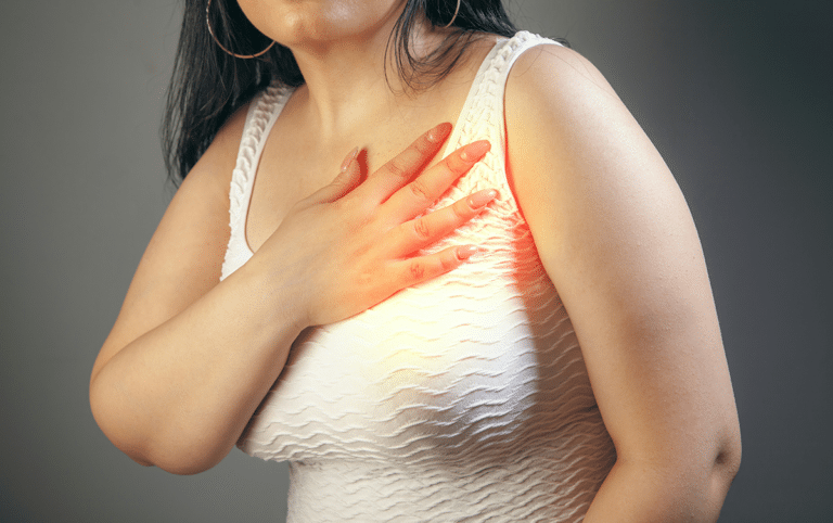 Woman holding a hand over her chest, illustrating heart palpitations during perimenopause