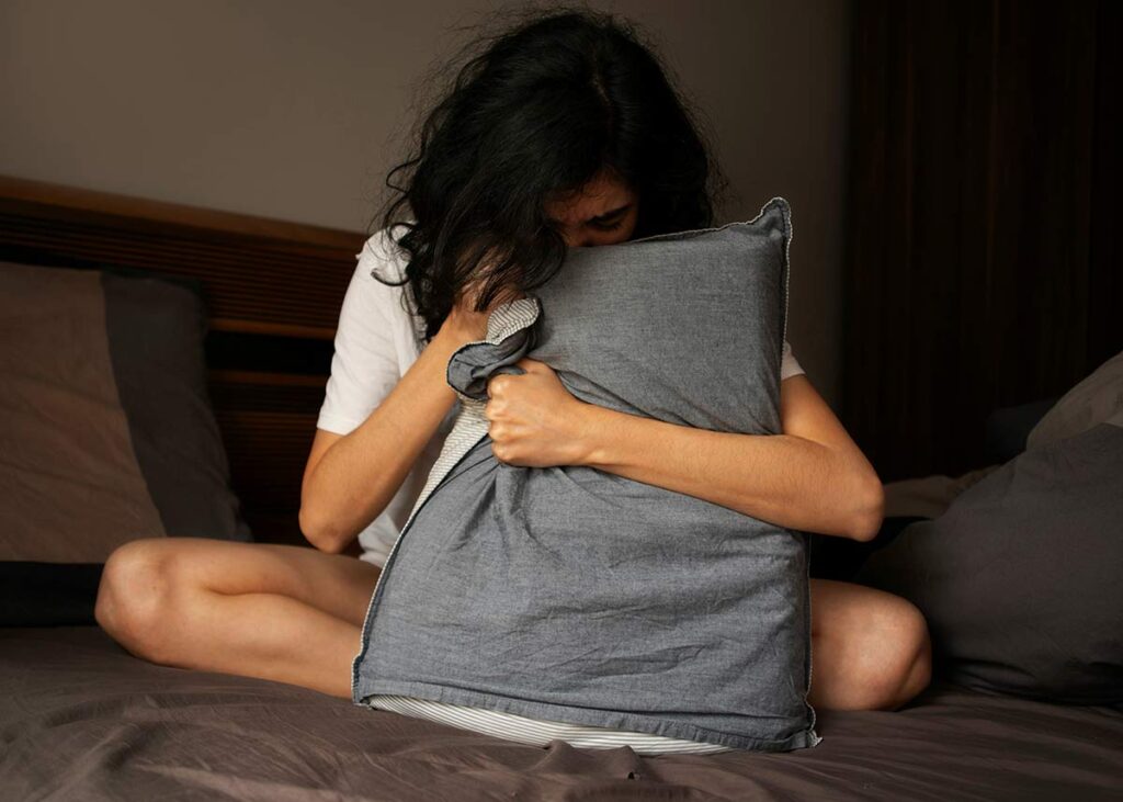 Woman in her 40s waking up hot at night, illustrating night sweats and disrupted sleep during perimenopause