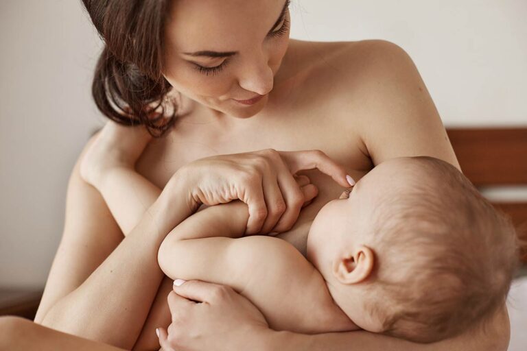 Mother holding her newborn baby skin-to-skin against her bare chest