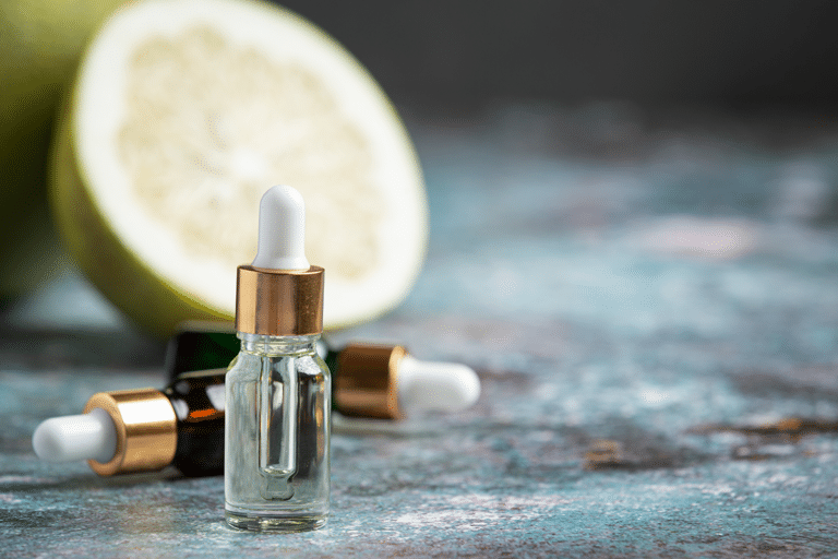 Vitamin C face serum bottles displayed beside a halved grapefruit for a brightening skincare routine