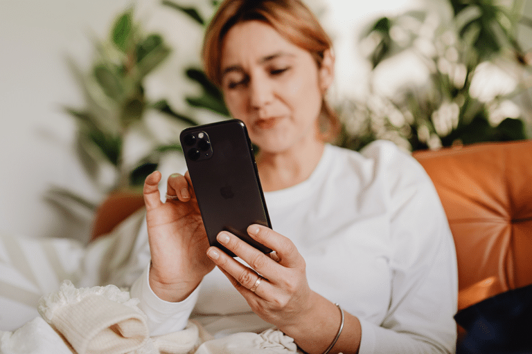 woman reading message on phone thoughtful at home