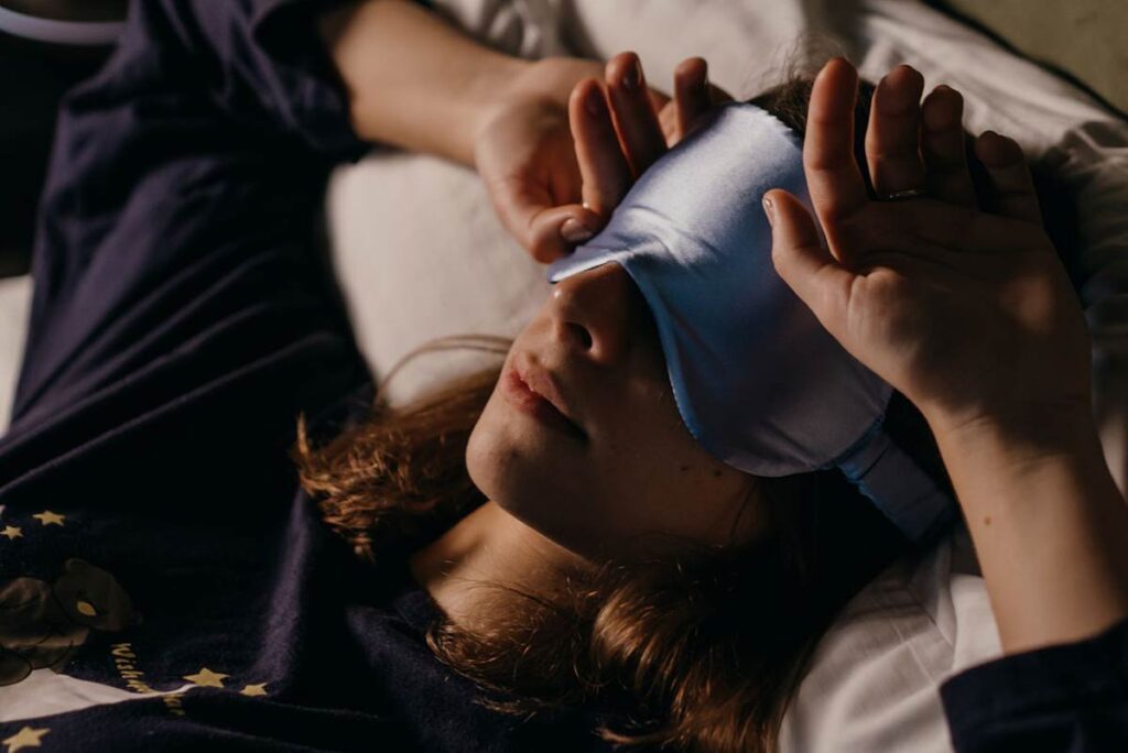 Woman wearing a sleep mask to block out light while resting